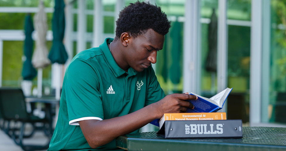 USF graduate student reading a book.